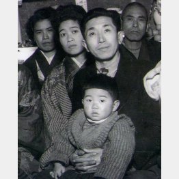 両親に抱えられる筆者（中央＝本人提供）